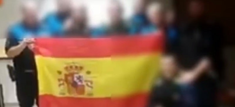 El grup de policies, amb la bandera espanyola, durant el servei. 
