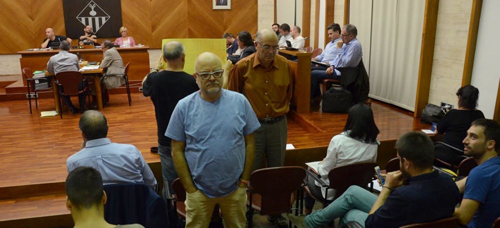 Foto portada: assistents al ple, dempeus i d'esquenes mentre intervé el portaveu del PP, Esteban Gesa. Autor: David B. 