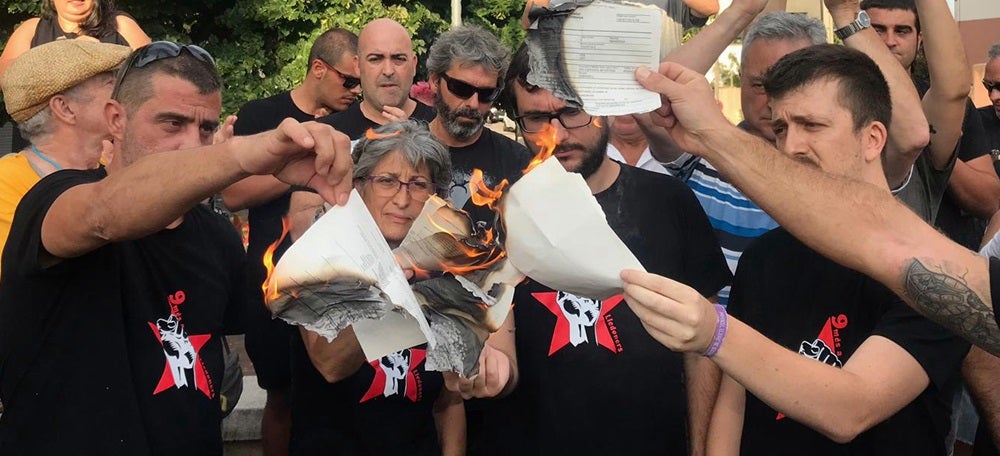 Foto portada: tres dels encausats, cremant la citació. Autor: Samuel Martínez.