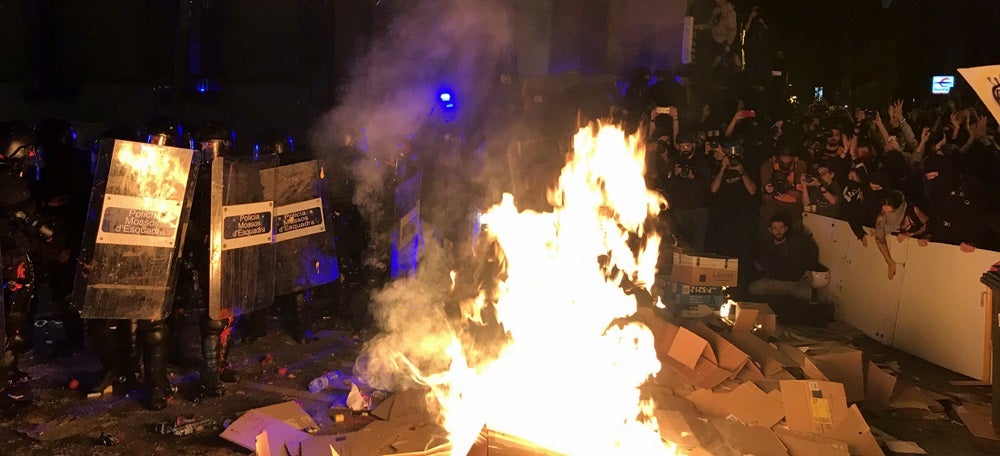 Una foguera davant d'un cordó policial en el marc d'una concentració de rebuig a la sentència de l'1-O el 15 d'octubre a Barcelona. Pla general. (Horitzontal)