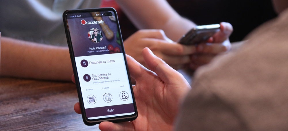 Pla detall d'un telèfon mòbil amb l'aplicació de Quictendr a la pantalla. Imatge del 21 de maig de 2020. (Horitzontal)