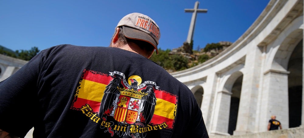 Pla mig d'un home amb una bandera franquista al Valle de los Caídos. Imatge del 24 d'agost del 2018. (Horitzontal)