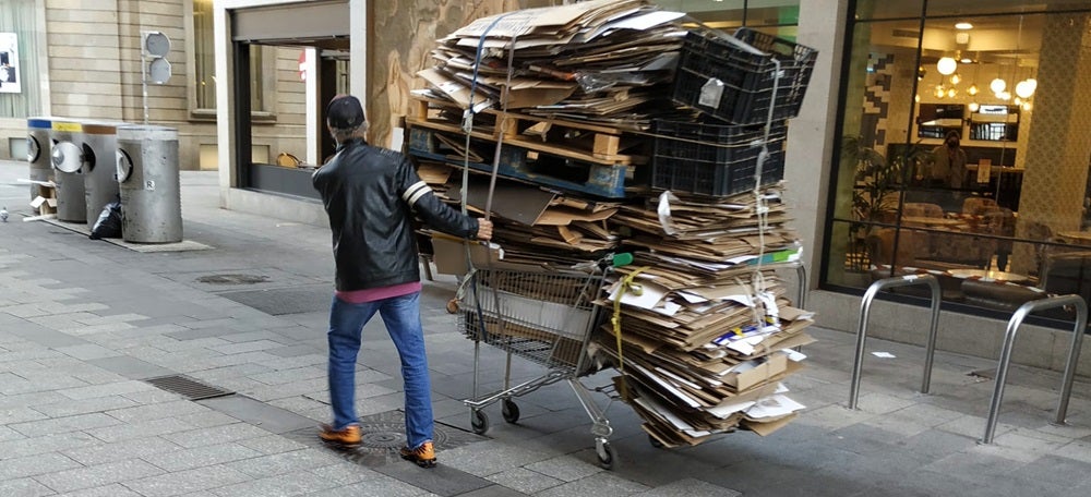 Foto portada: un home portant un carro ple de cartró, la setmana passada al centre de Sabadell. Autor: J.d.A.