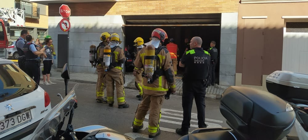 Foto portada: membres dels Bombers i de la Policia Municipal, al garatge on s'ha produït l'incendi. Autora: M.Reina. 