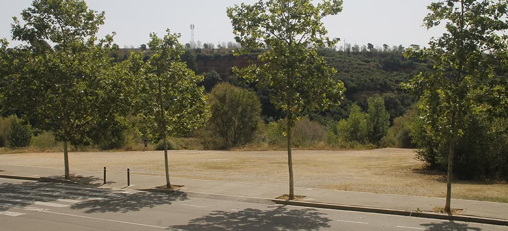 El solar on es vol construir una piscina d'onades, al costat de la Bassa, davant la Pista Coberta i darrera del riu Ripoll, el 5 de juliol. Autora: Lucía Marín.