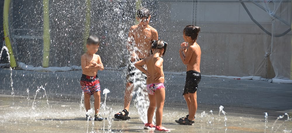 Nens refrescat-se a la font de la plaça Sat Roc. Autor: David B.