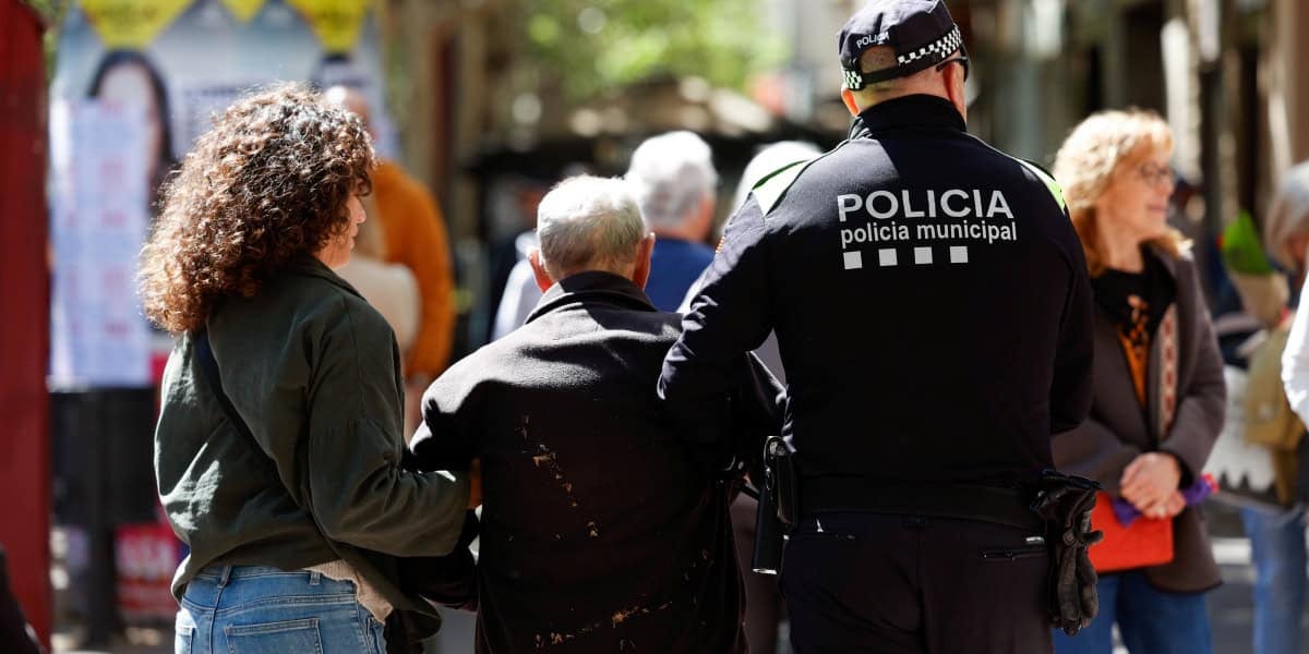 Un agent de la Policia Municipal assistint l'home que ha caigut a la Rambla. Autor: D.Jiménez.