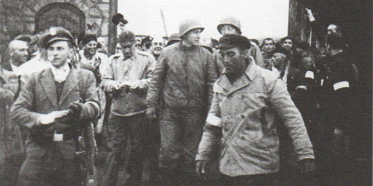  Eduard Garrigós, en primer pla amb gorra negra, el dia de l'alliberament de Mauthausen. Al darrere seu, el coronel Richard Seibi, de la 11ª Divisió Blindada nord-americana (5 maig 1945)