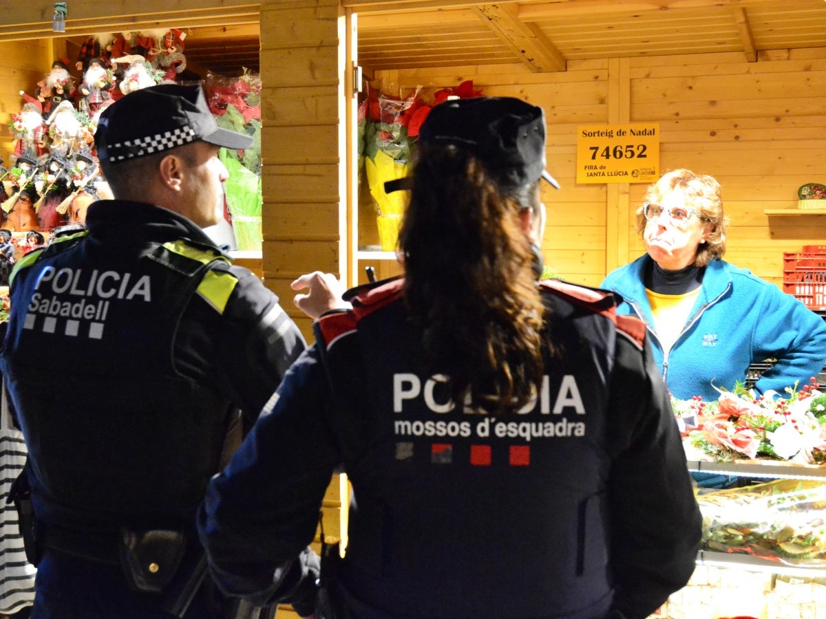 Un agent de la Policia Municipal i una dels Mossos d'Esquadra, a la fira de Santa Llúcia. Autor: J.d.A. 