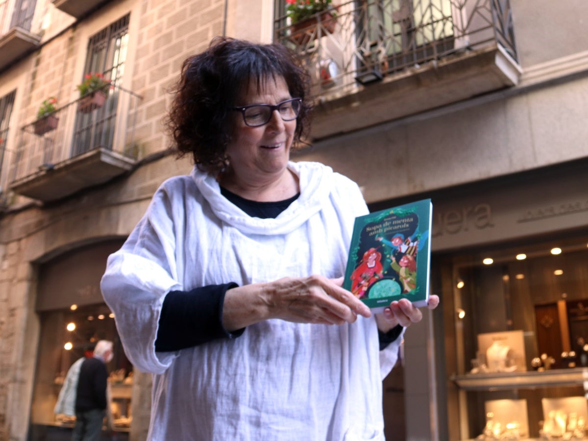 Anna Fité amb 'Sopa amb menta i picarols', davant del balcó on habitualment pengen el Tarlà de Girona amb el seu llibre a la mà el 23 de març de 2021. Autor: ACN. 