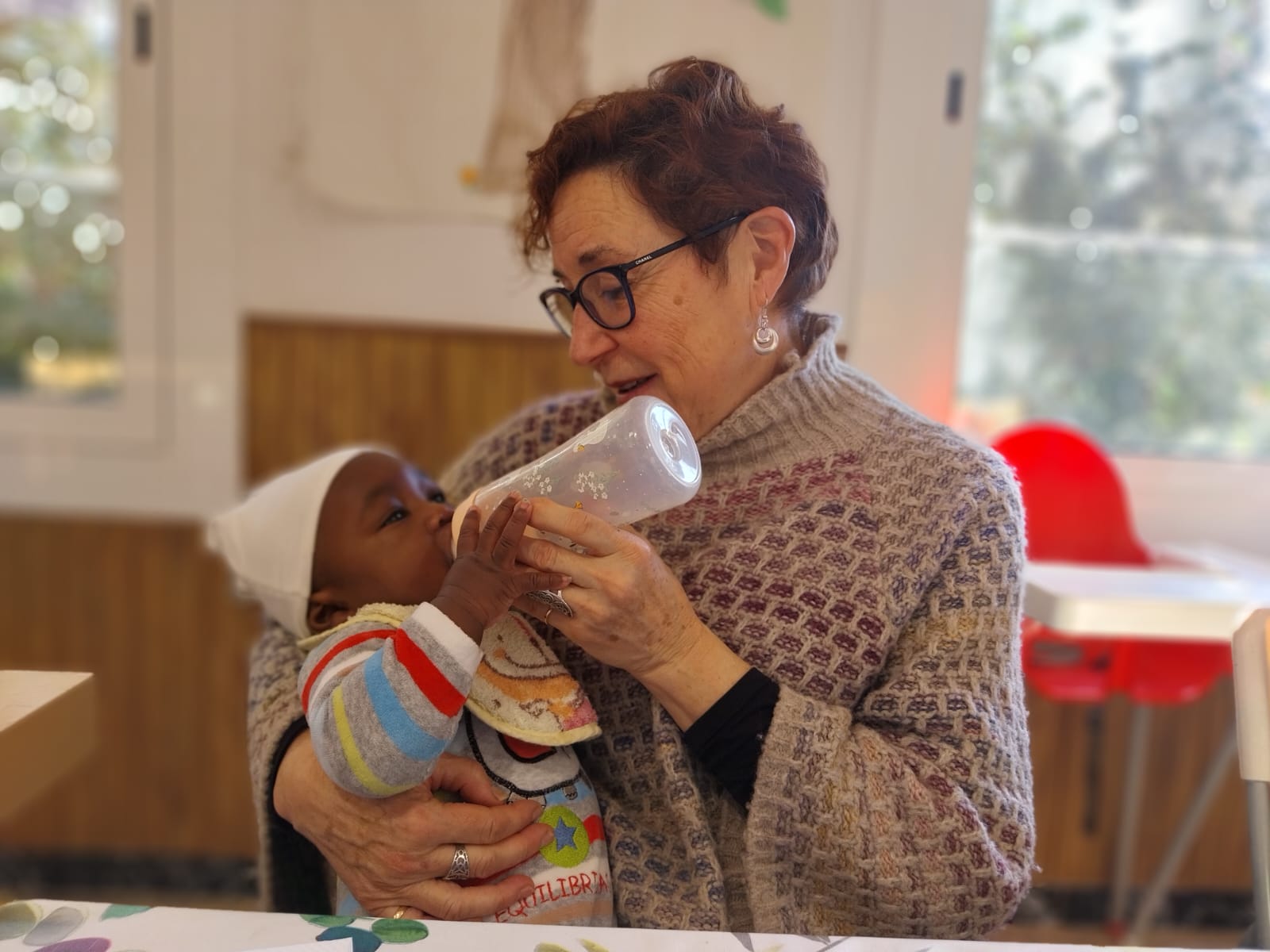 Una voluntària dona el biberó a un nadó a La Closca, el projecte maternoinfantil de Càritas Sabadell. Autor: R.G.M