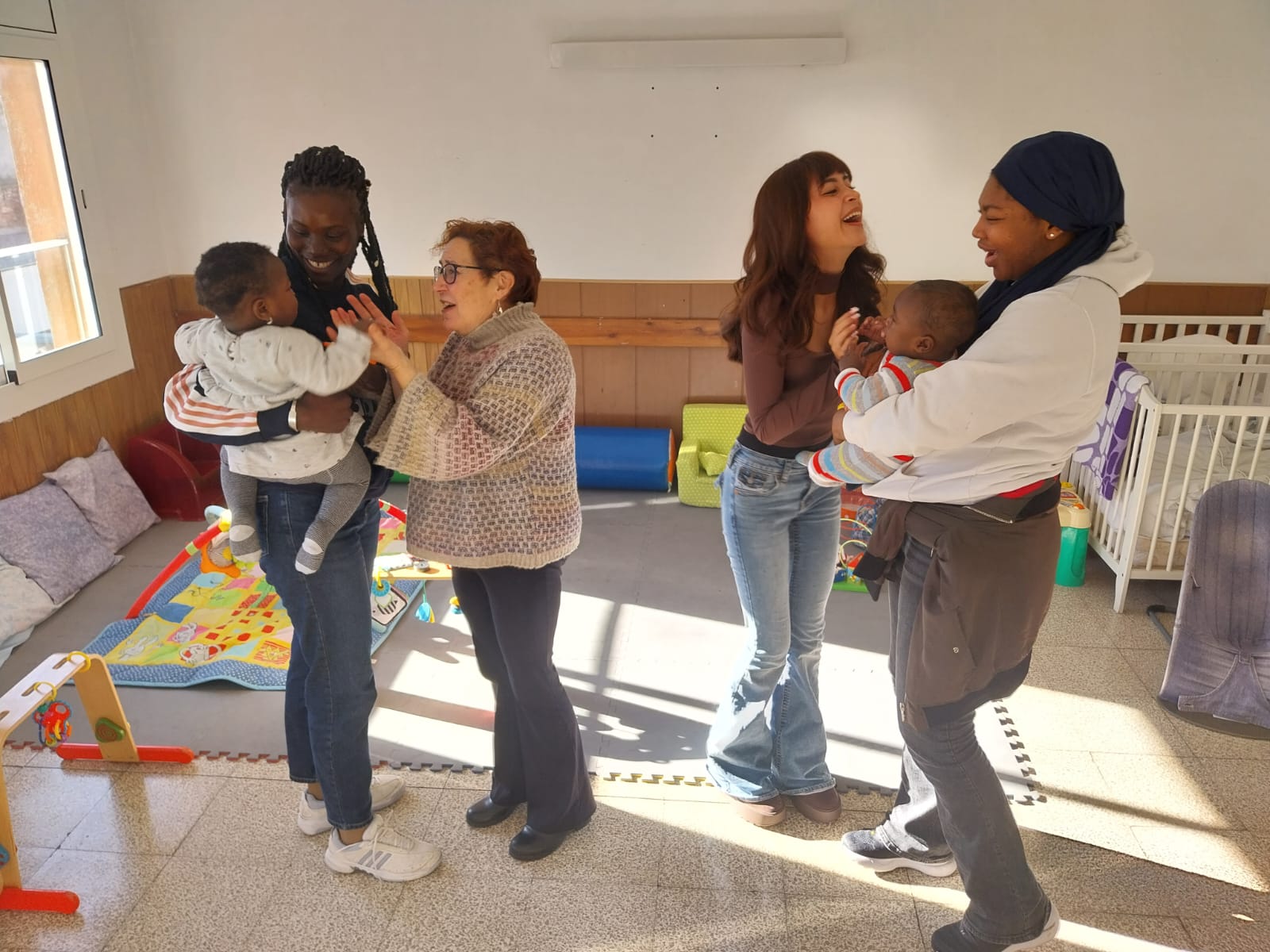 Mares i voluntàries comparteixen un moment de joc i música amb els nadons a La Closca, el projecte maternoinfantil de Càritas Sabadell. Autor: R.G.M