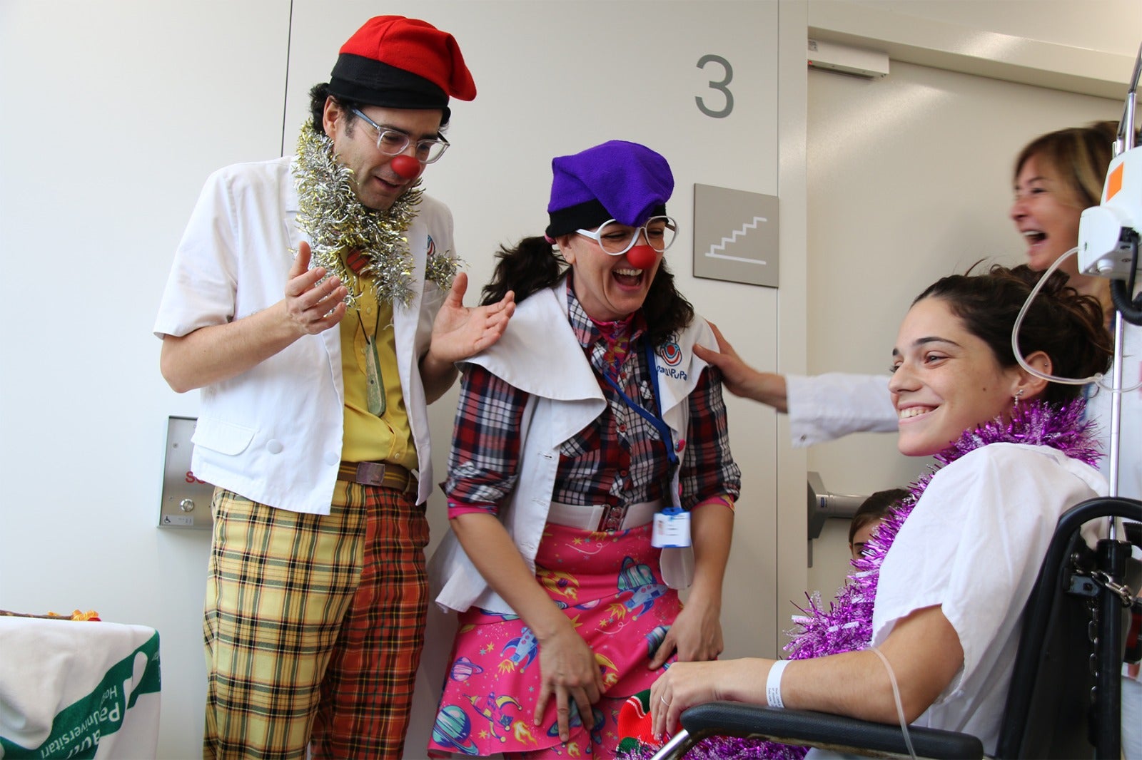 Amina Biodramina i Gota-Gota, professionals de Pallapupas, acompanyen una pacient a l’Hospital Parc Taulí dins el circuit hospitalari. Autor: Pallapupas