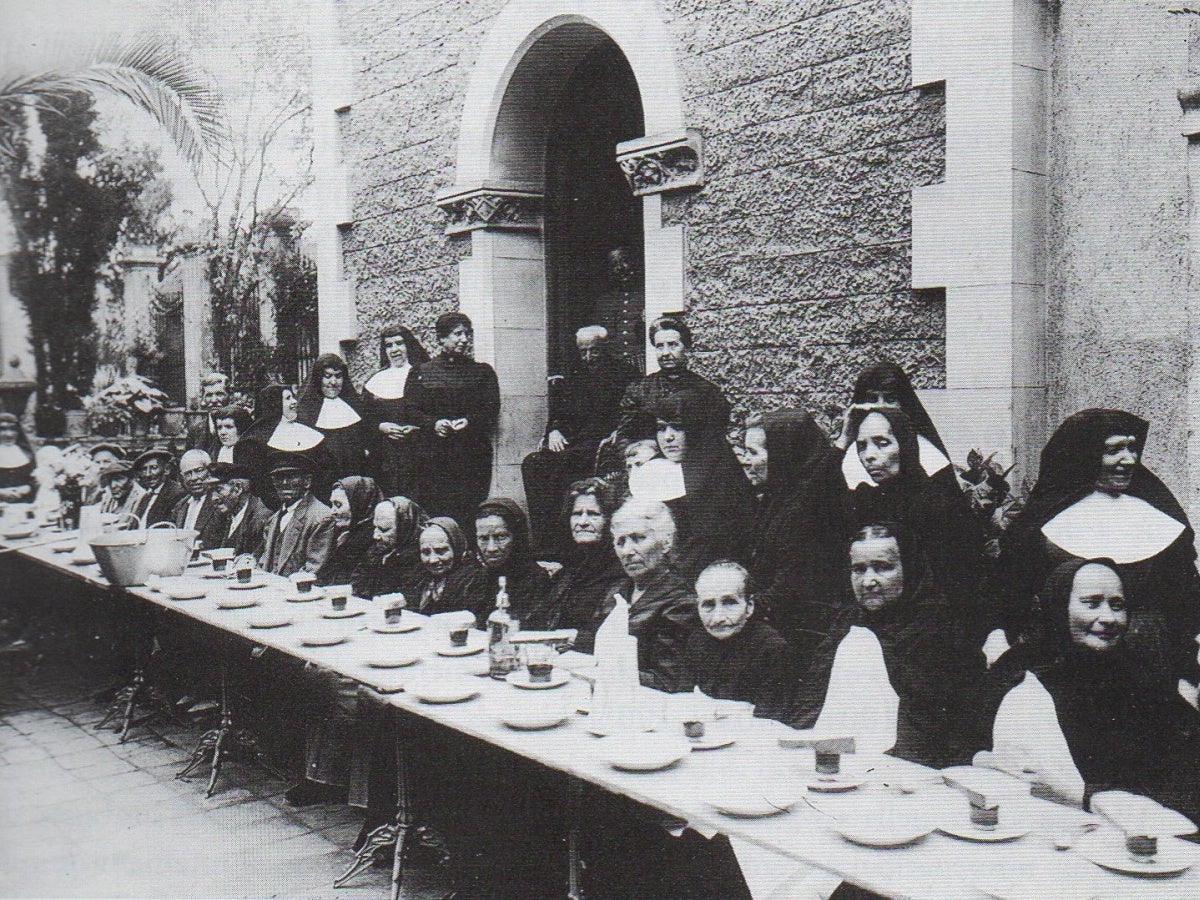 Berenar a l'Asil de les Germanetes dels Ancians Desemparats amb Sardà i Salvany, assegut a la porta. 1912 aprox. Autor: F. Casañas/AHS 