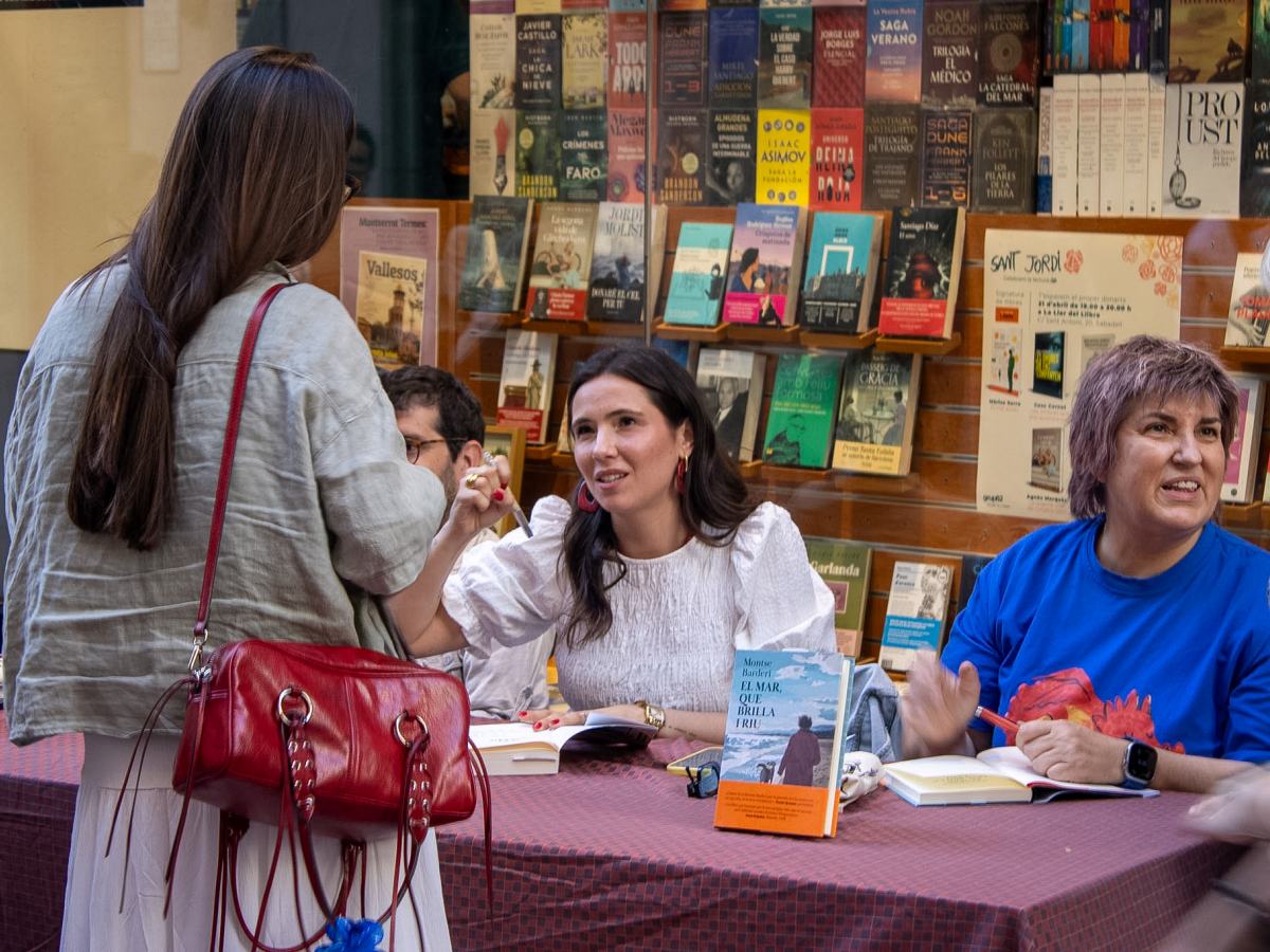 Carla Clavera, xerrant amb una lectora a la La Llar del Llibre. 
