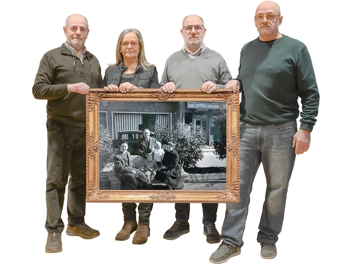 Els germans Fàbregues sostenint una foto familiar davant la primera seu de La Llar del Llibre.