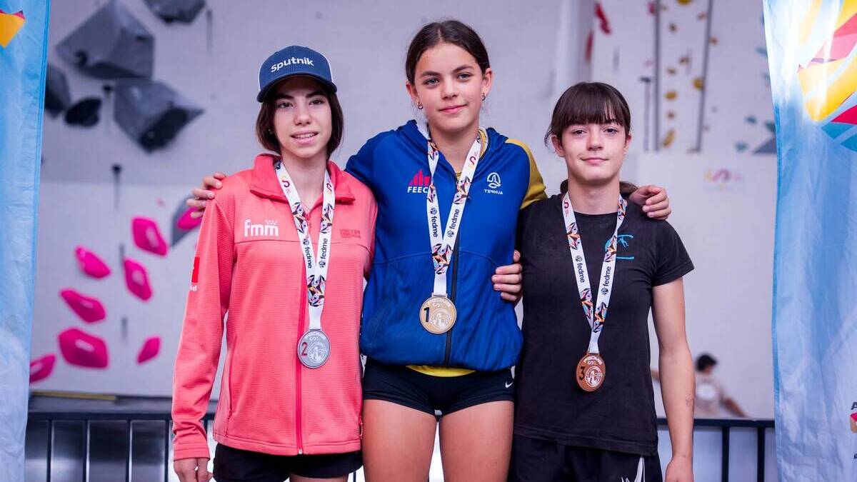La Ivet al mig, amb la medalla d'or en un podi. Cedida