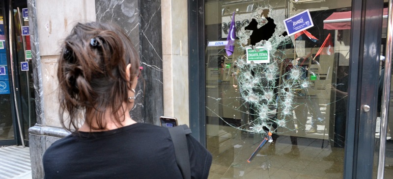 Foto portada: una assistent a la manifestació, veient els vidres trencats. Autor: J.d.A.