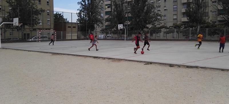 Joves jugant en el patí obert de l'escola Espronceda, el passat estiu.