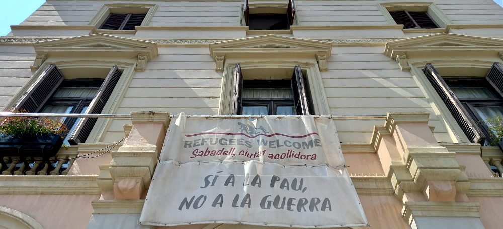 Pancarta pels refugiats a la plaça del doctor Robert, aquest dimecres. Autor: David B.