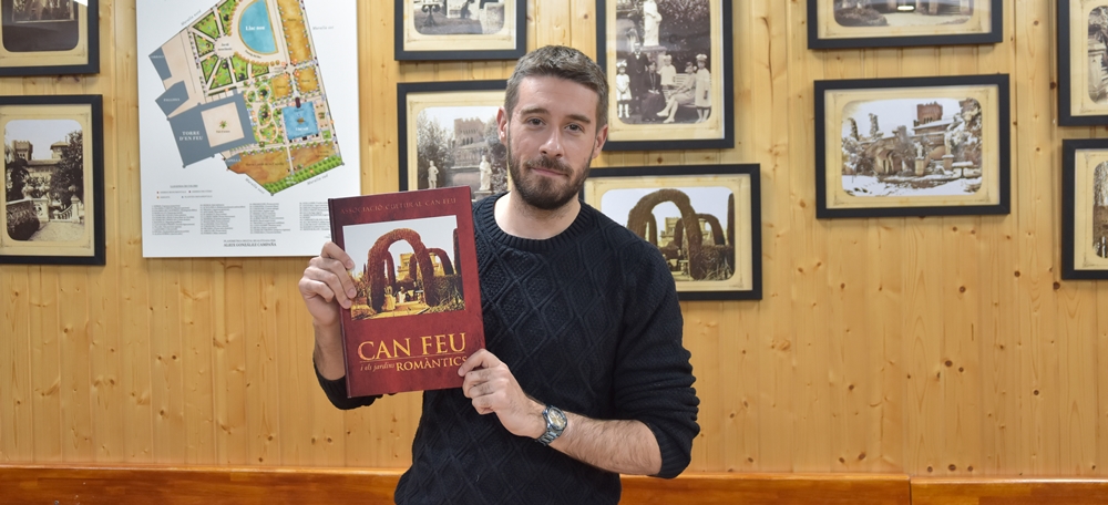 Aleix González mostrant el seu segon llibre sobre els Jardins del castell Can Feu davant de l'exposició fotogràfica sobre els mateixos. Autor: David Chao.