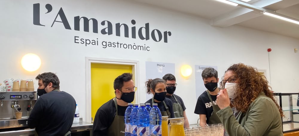 Foto portada: Els treballadors de l'espai gastronòmic l'Amanidor atenent durant l'acte de presentació. Autor: Àlex Bello