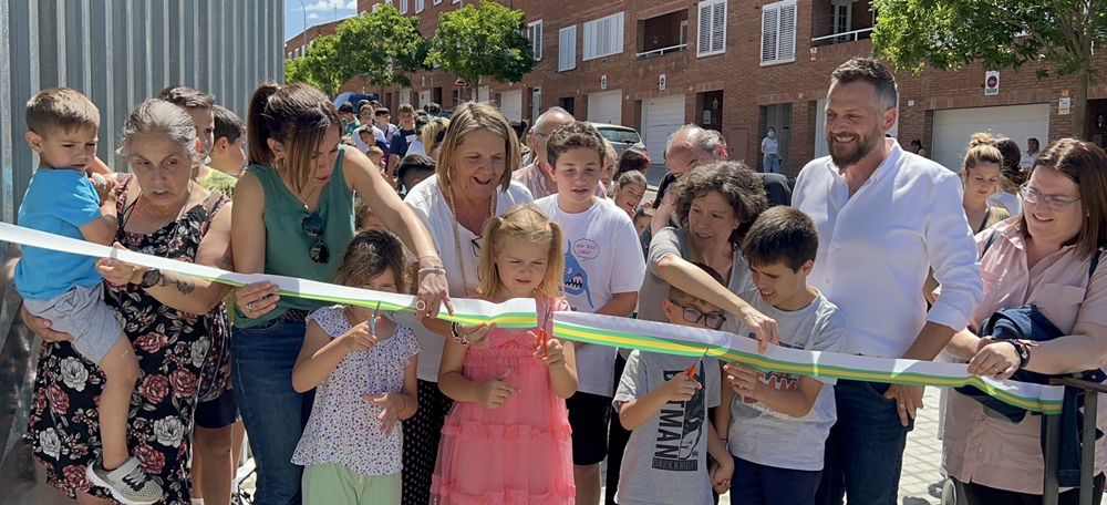 Dues nenes tallant la cintura d'inauguració del camí escolar del Pau Casals, aquesta tarda. Autor: cedida.