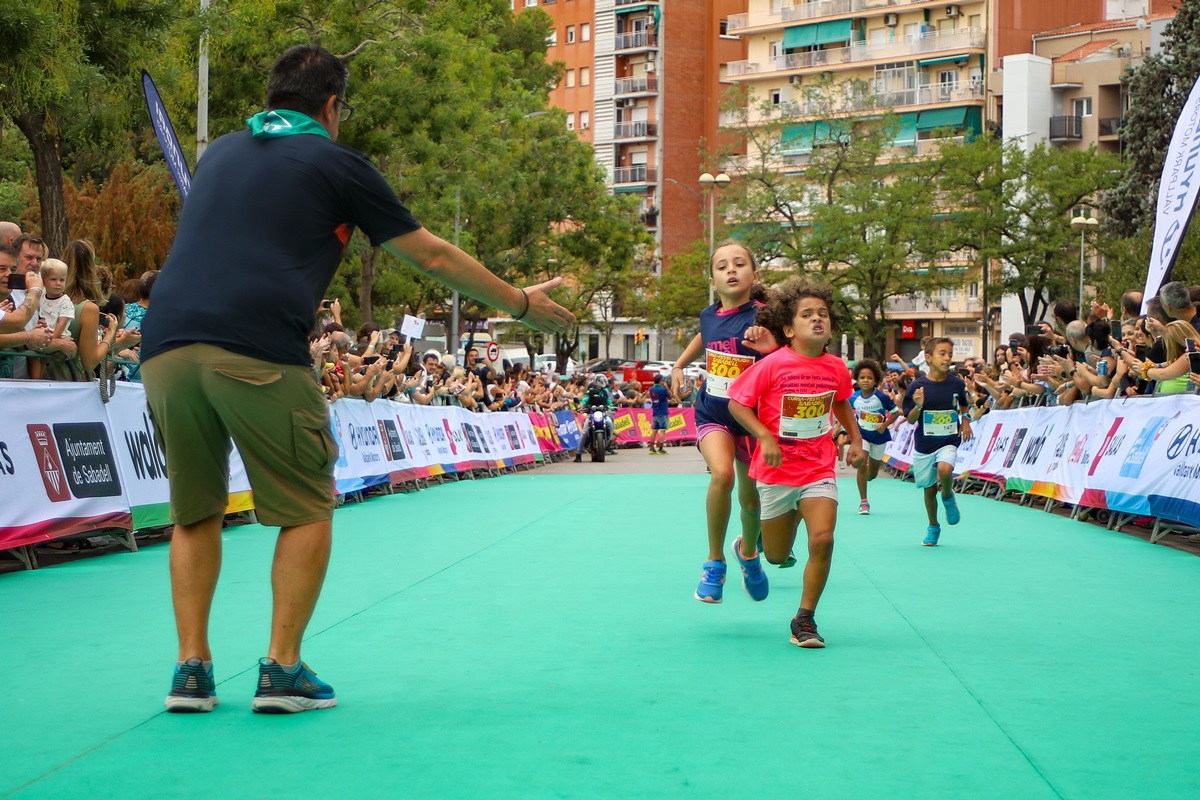 Arribada dels primers corredors de la cursa de 300 metres, per a infants nascuts els anys 2016 i 2017, els més petits de la cursa.