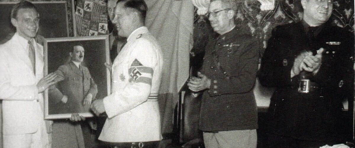 Entrega del retrato de Hitler. Elhers de blanco con la esvástica, el coronel Feijóo y el alcalde Marcet (1941). Autor desconocido/AHS.
