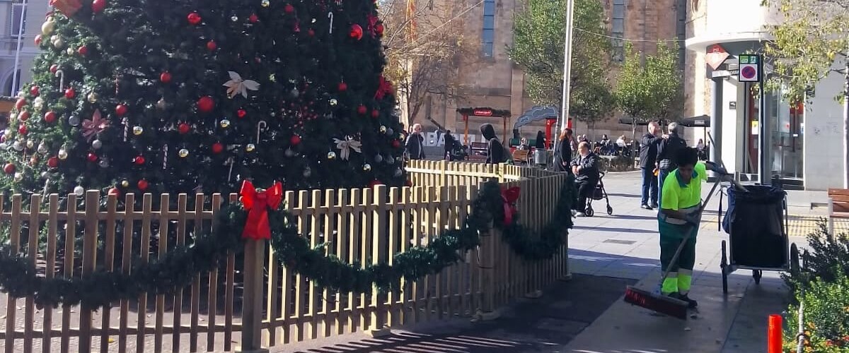 Foto portada: una operària de neteja viària, al costat del gran arbre de Nadal del Passeig. Autor: SMATSA / X (abans Twitter).