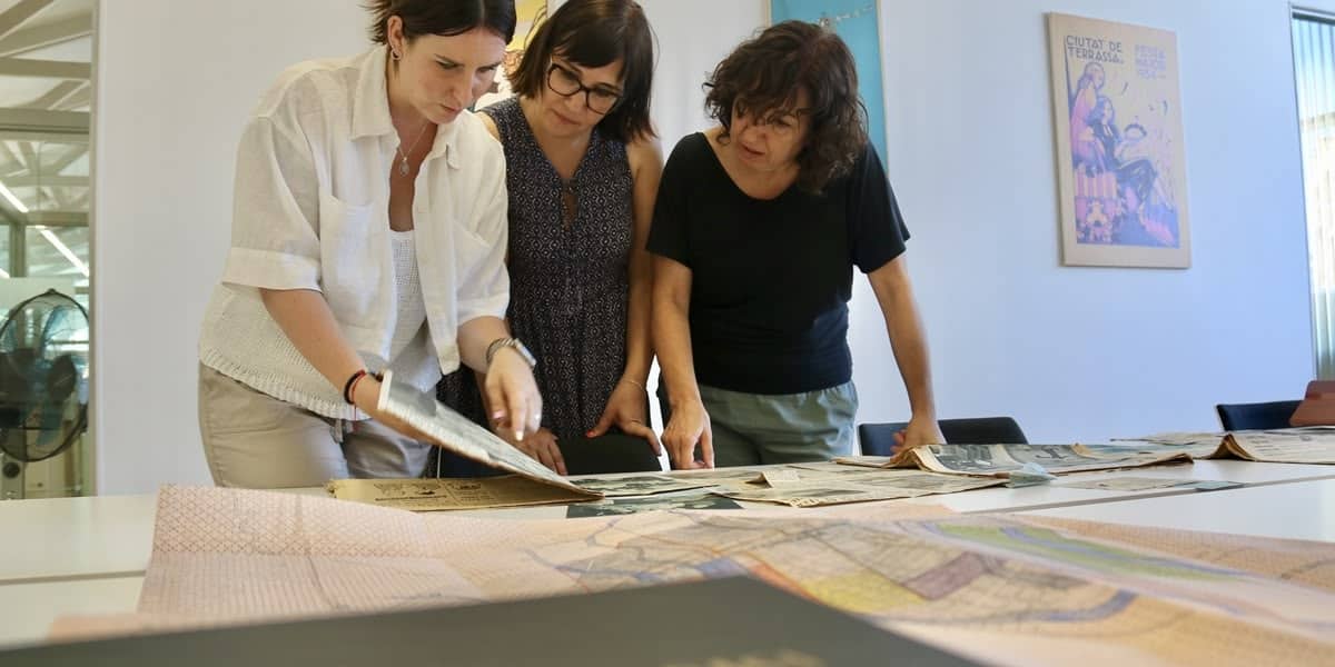 La regidora de Rieres de Terrassa, la presidenta de l'entitat i la secretària, mirant expedients. Autor: ACN.
