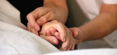 Una infermera, amb un pacient de cures pal·liatives. Autor: ACN.