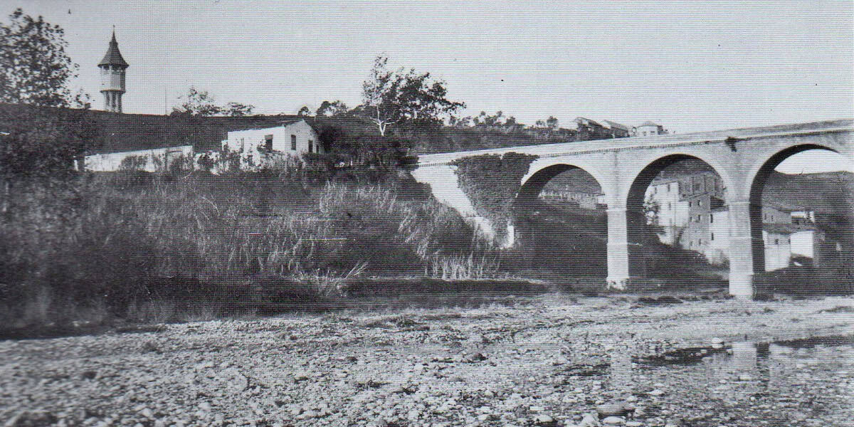 El Pont de la Salut, cap el 1925. R. Cabrera. Al costat, la taverna de Can Titoles.