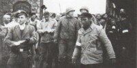 Eduard Garrigós, en primer pla amb gorra negra, el dia de l'alliberament de Mauthausen. Al darrere seu, el coronel Richard Seibi, de la 11ª Divisió Blindada nord-americana (5 maig 1945)