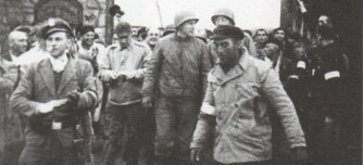Eduard Garrigós, en primer pla amb gorra negra, el dia de l'alliberament de Mauthausen. Al darrere seu, el coronel Richard Seibi, de la 11ª Divisió Blindada nord-americana (5 maig 1945)